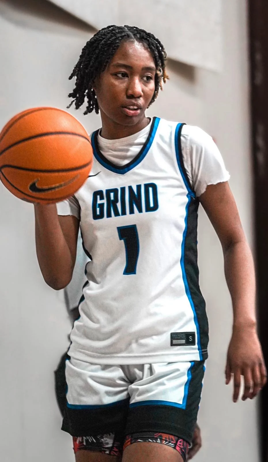 Grind Prep girls basketball player holding a basketball in her school jersey